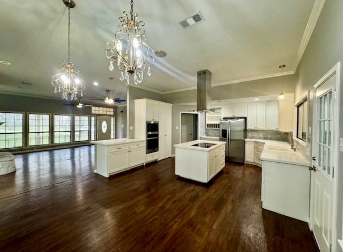 327 County Road 735 Angleton, TX 77515 - Photo 11 of 39 a kitchen with stainless steel appliances a stove top oven a refrigerator a dining table and chairs with wooden floor