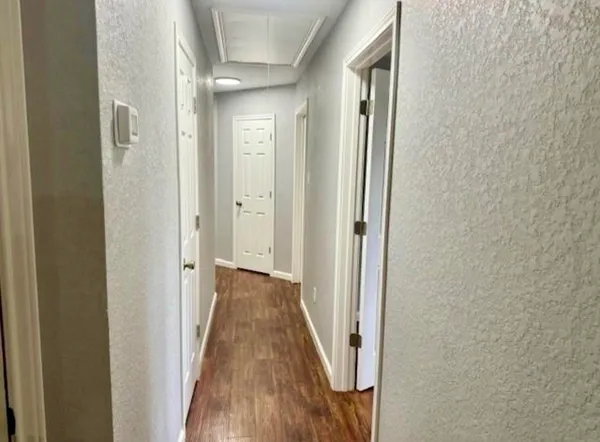 a view of a hallway with wooden floor and staircase
