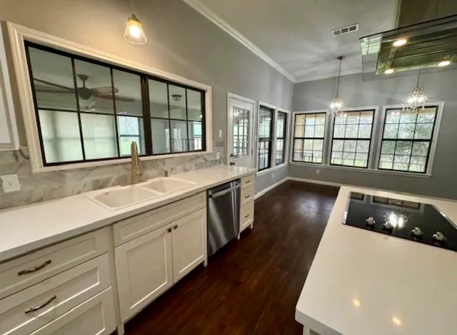 a kitchen with stainless steel appliances a large window sink and cabinets