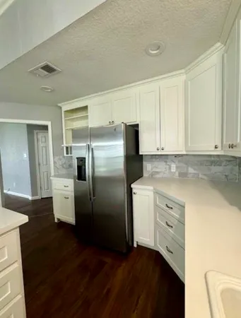 a kitchen with a refrigerator sink and cabinets