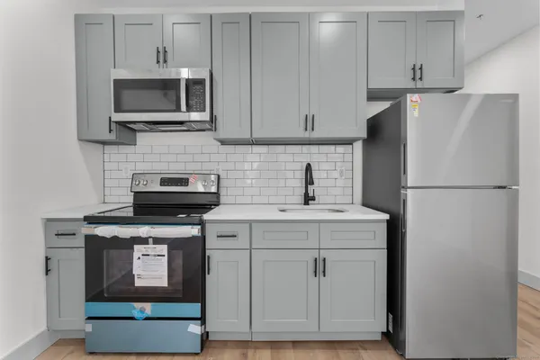 a kitchen with cabinets stainless steel appliances and a counter space