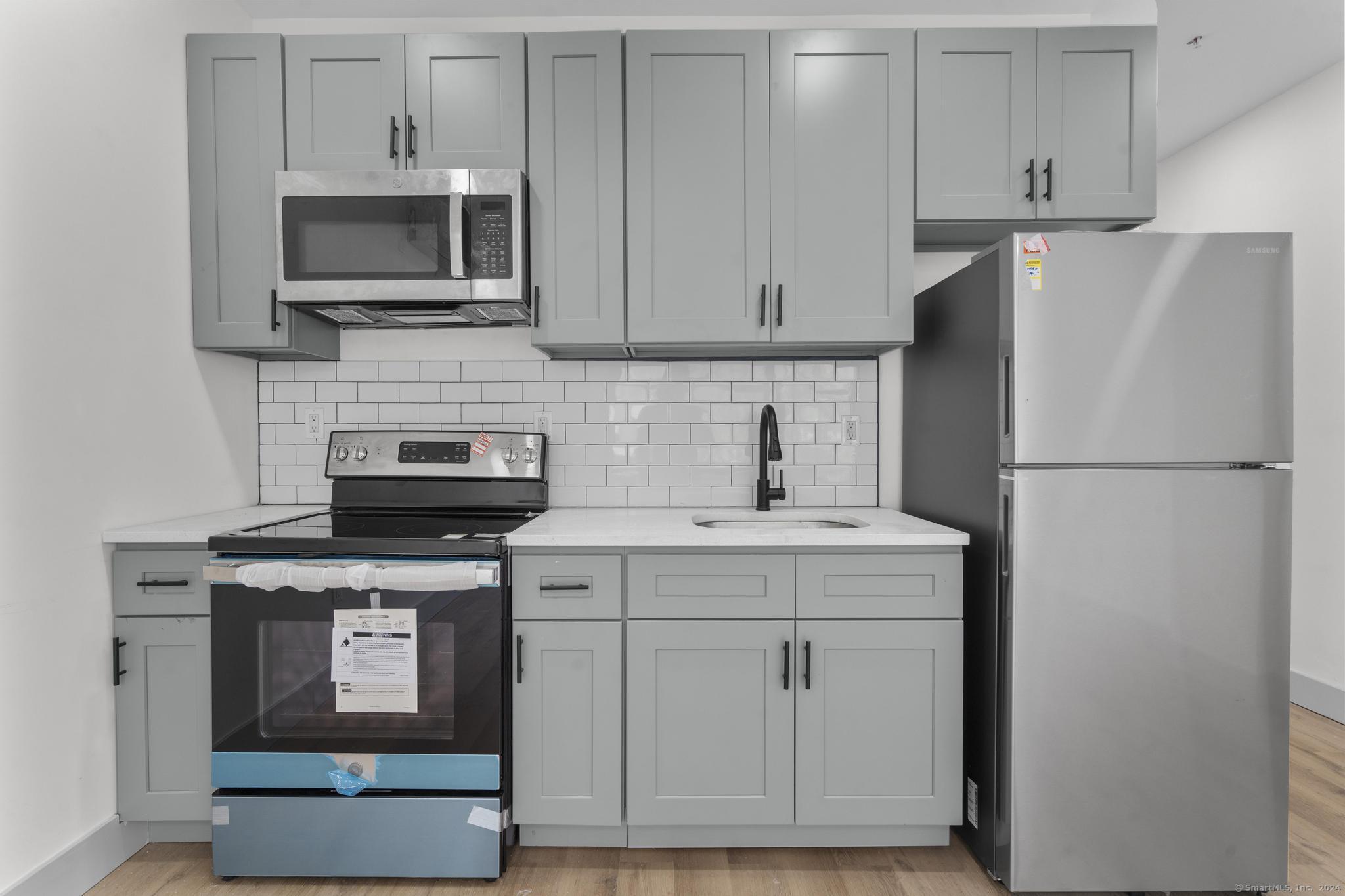 111 Bank Street, Unit 2B Waterbury, CT 06702 - Photo 1 of 15 a kitchen with cabinets stainless steel appliances and a counter space