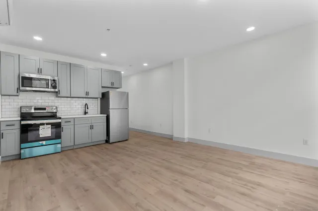 a kitchen with stainless steel appliances a refrigerator and a stove top oven