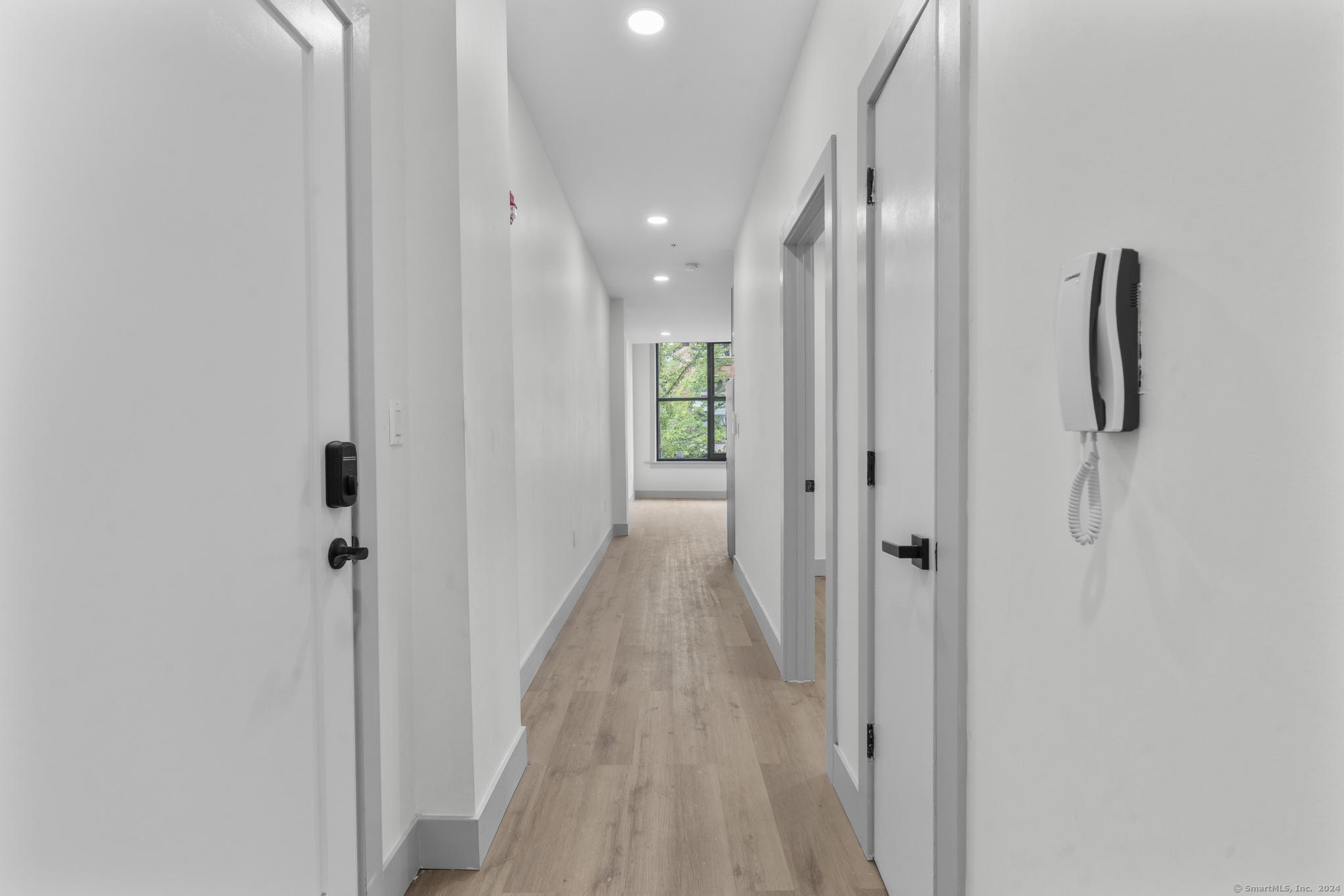 111 Bank Street, Unit 2B Waterbury, CT 06702 - Photo 6 of 15 a view of a hallway with wooden floor and staircase