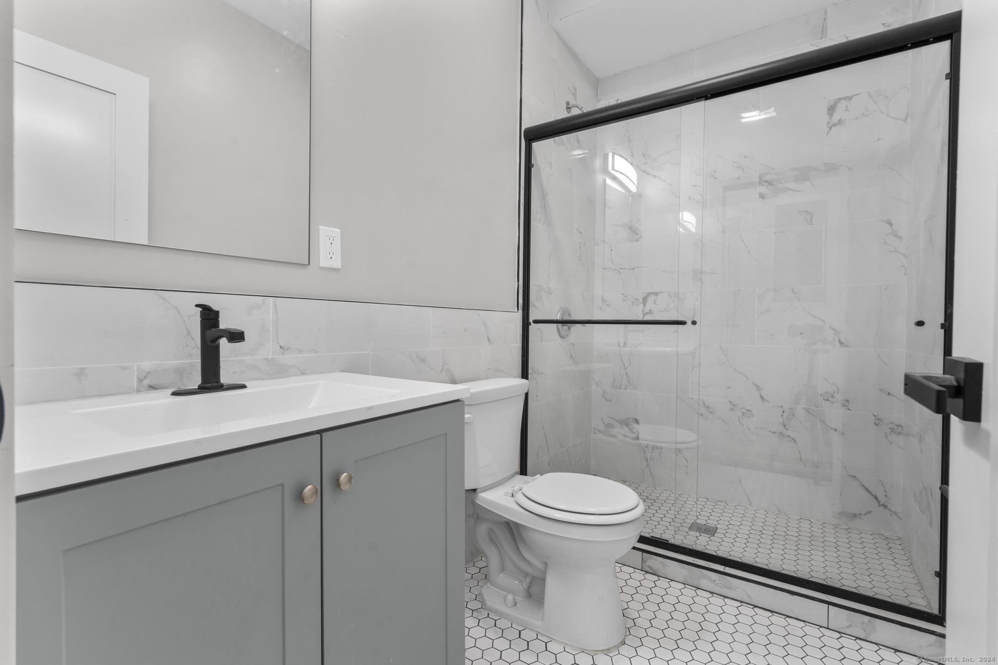 111 Bank Street, Unit 2B Waterbury, CT 06702 - Photo 8 of 15 a bathroom with a toilet sink and shower