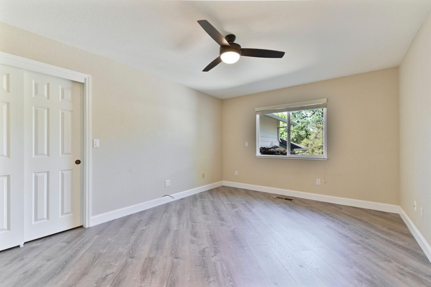 234 Mistletoe Court Angels Camp, CA 95222 - Photo 35 of 80 an empty room with wooden floor ceiling fan and windows