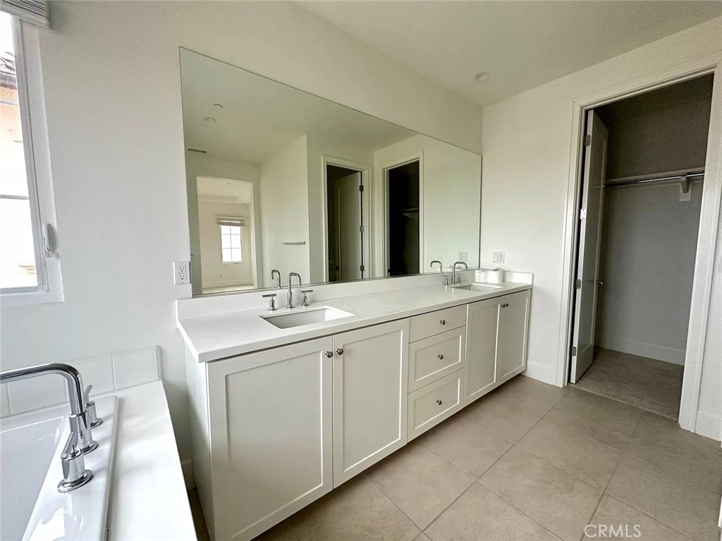 116 Avento Irvine, CA 92602 - Photo 9 of 12 a spacious bathroom with a double vanity sink a mirror and a shower