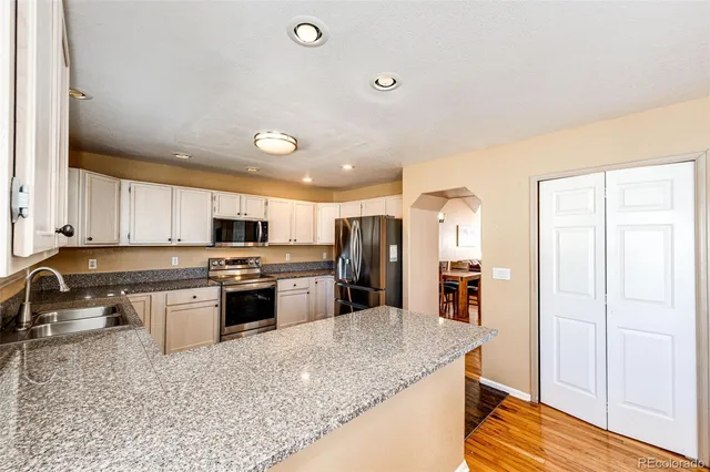 a kitchen with stainless steel appliances granite countertop a sink stove and refrigerator