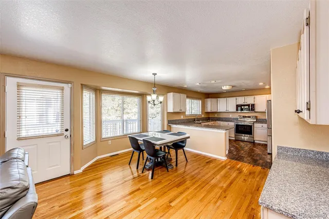 a kitchen with a table chairs and wooden floor