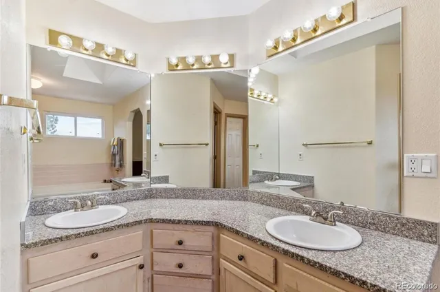 a bathroom with a granite countertop double sink and a mirror
