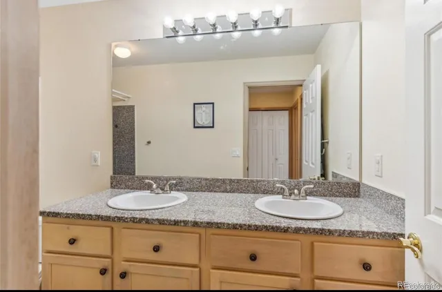 a bathroom with a granite countertop sink and mirror