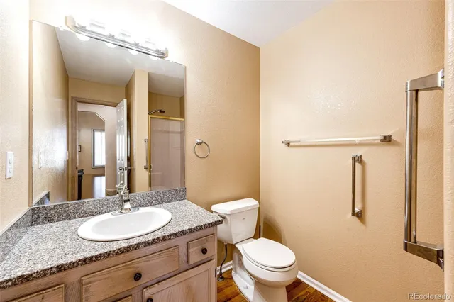 a bathroom with a granite countertop sink toilet and shower