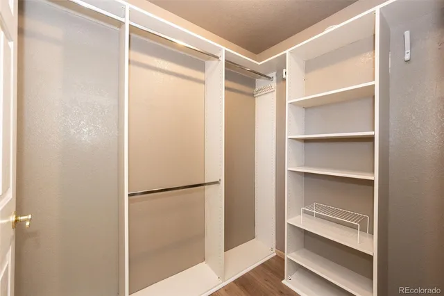 a view of walk in closet with empty racks