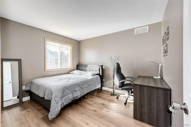 a bedroom with a bed and wooden floor