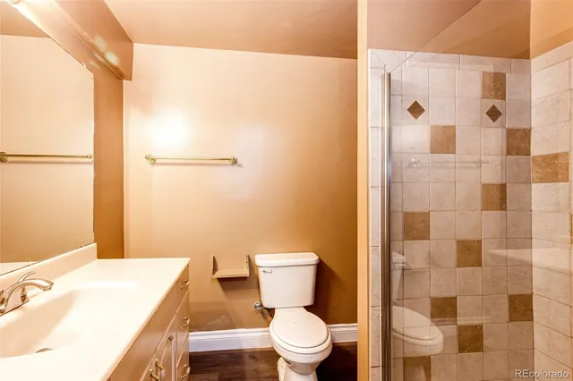 a bathroom with a granite countertop toilet a sink and a mirror
