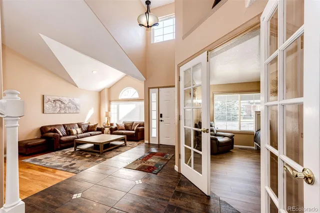 a living room with furniture large window and wooden floor