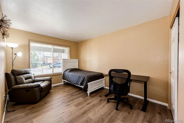a bedroom with a bed and wooden floor