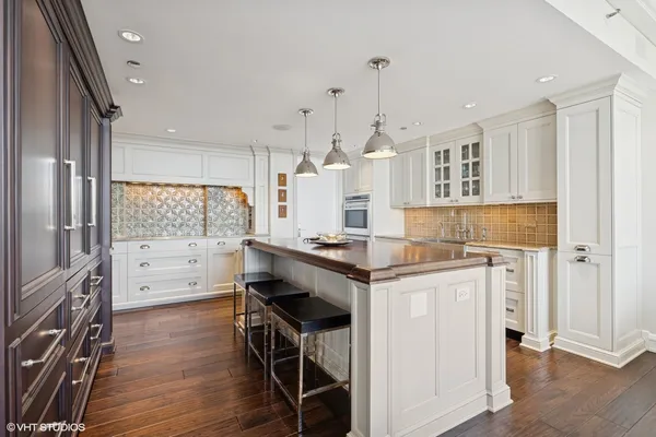 a kitchen with a refrigerator a sink and wooden floor