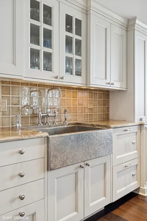 a kitchen with granite countertop white cabinets and sink