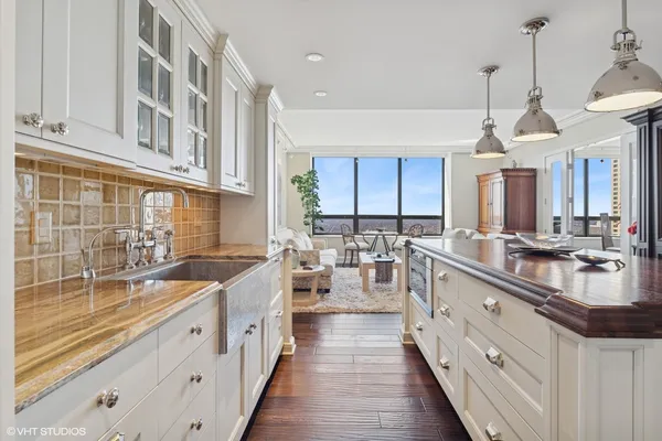a large kitchen with stainless steel appliances granite countertop a sink and dishwasher with white cabinets