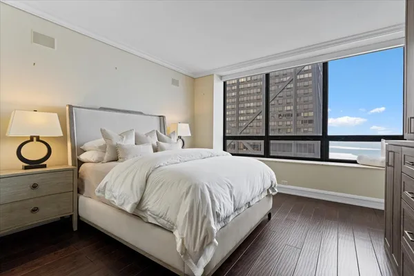 a large white bed sitting in a bedroom next to a window