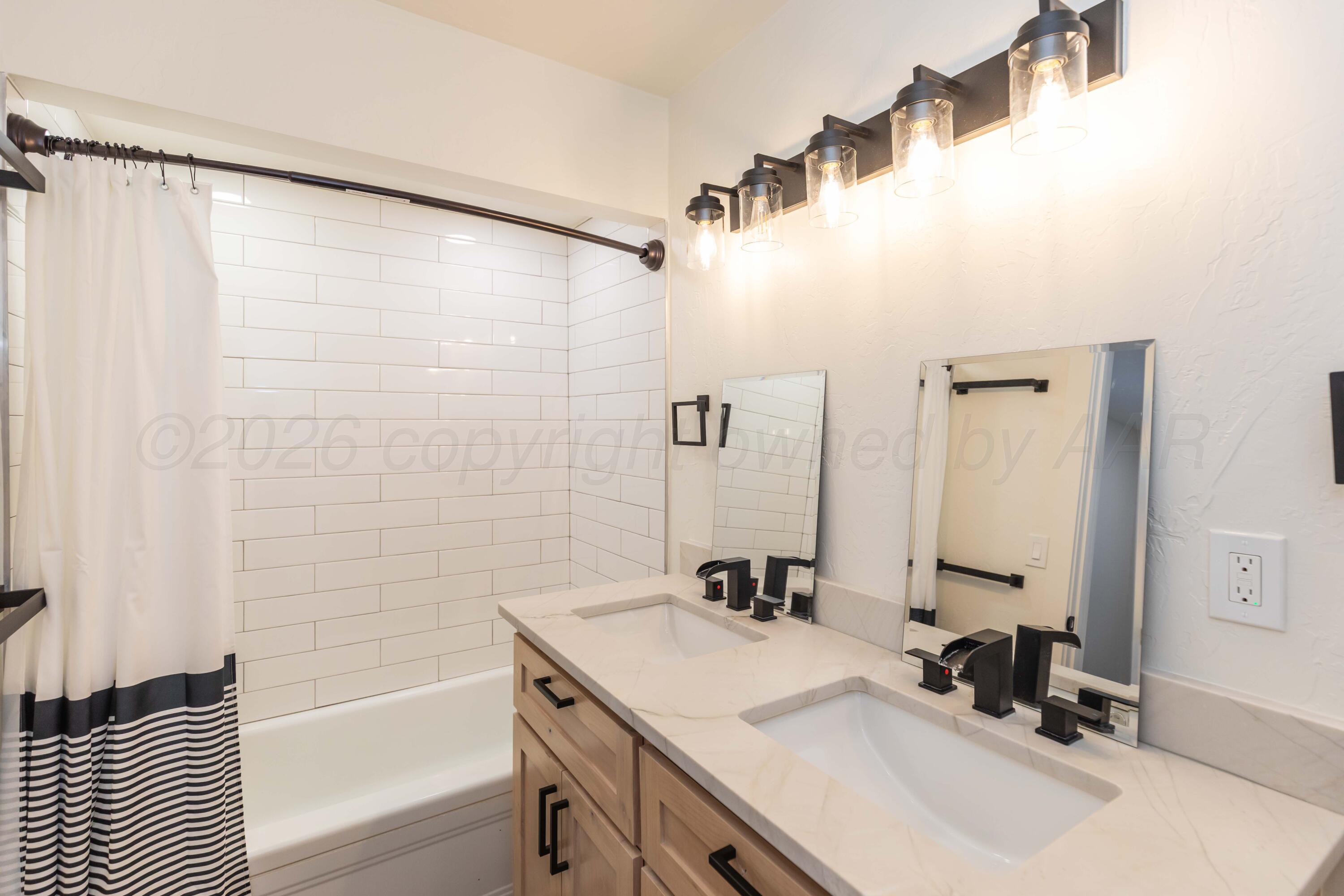 504 High Street Claude, TX 79019 - Photo 27 of 39 a bathroom with a sink double vanity and a tub