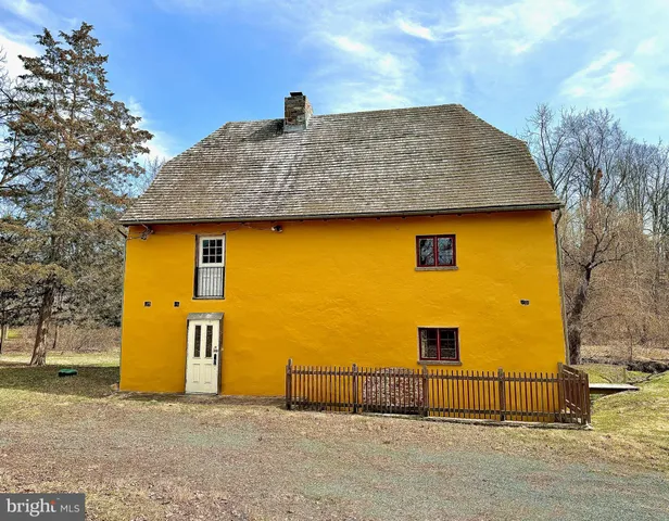 a front view of a house with large trees