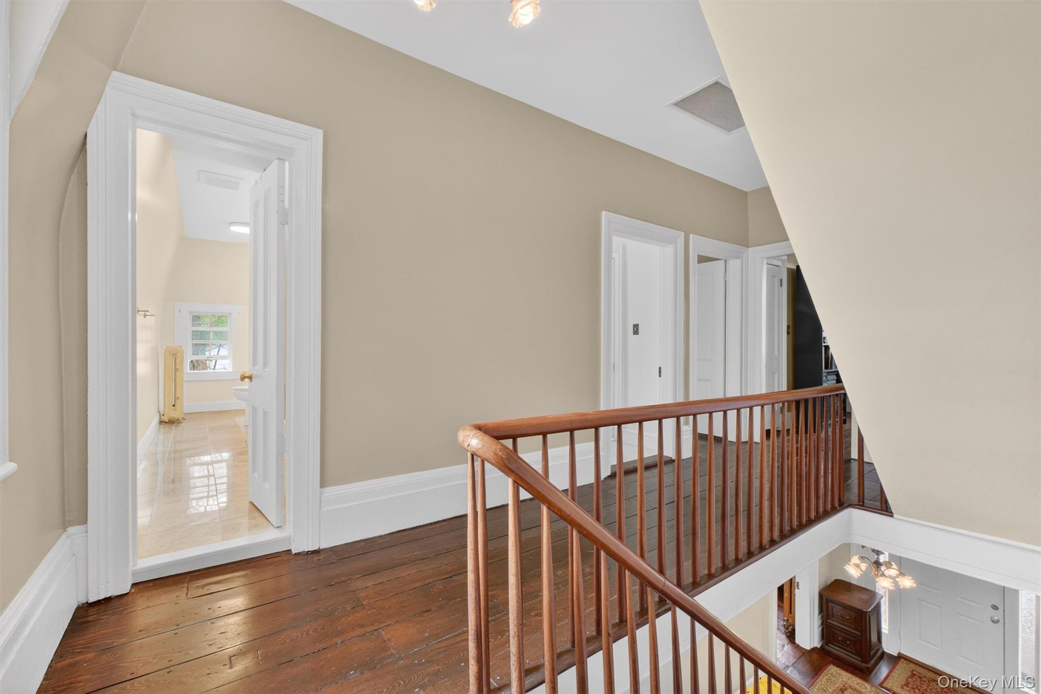 121 Old Glenham Road Fishkill, NY 12524 - Photo 25 of 50 Second-story hallway featuring rich hardwood flooring, a classic wooden balustrade, and doors leading to other living areas.
