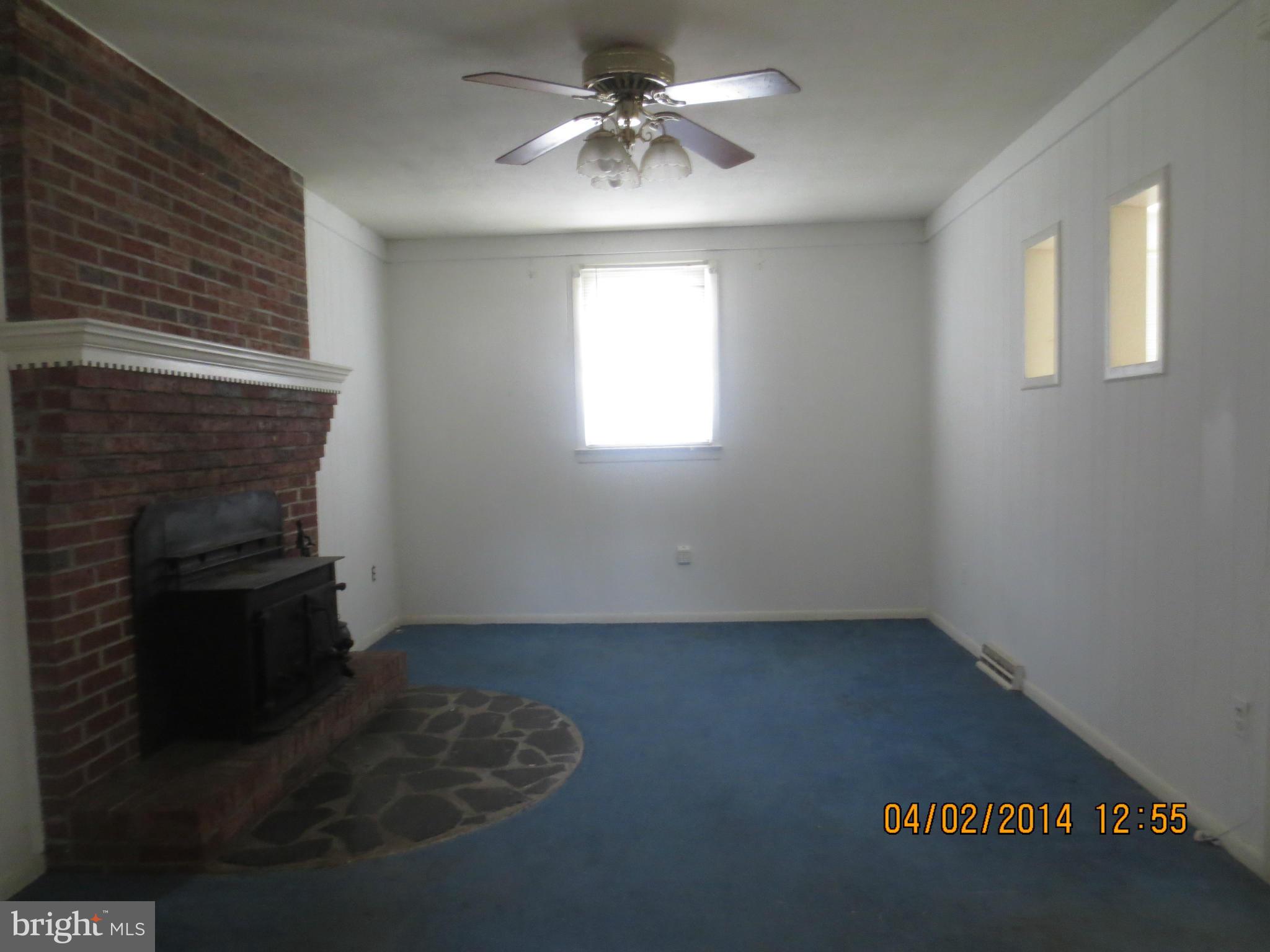 6796 Amherst Road Bryans Road, MD 20616 - Photo 4 of 10 an empty room with a fireplace and windows