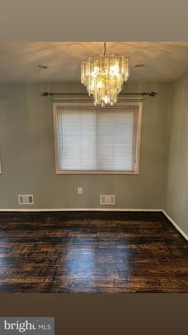 a view of a room with wooden floor and chandelier