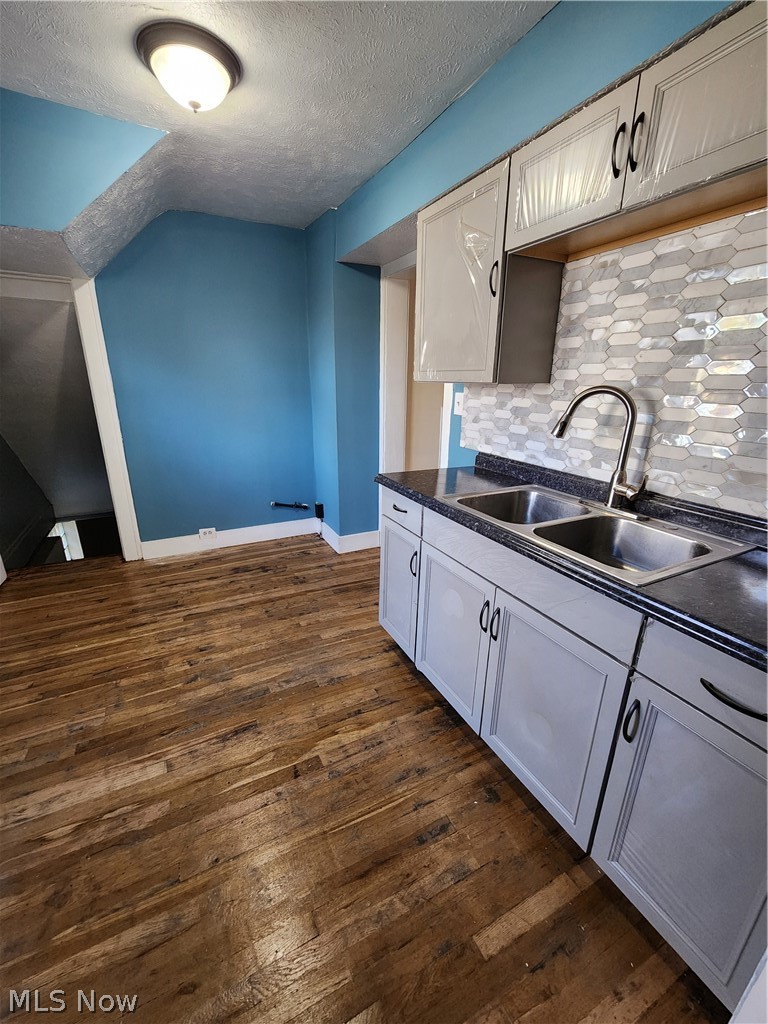 13500 Rugby Road Cleveland, OH 44110 - Photo 9 of 18 Kitchen with sink, backsplash, dark hardwood / wood-style floors, and a textured ceiling