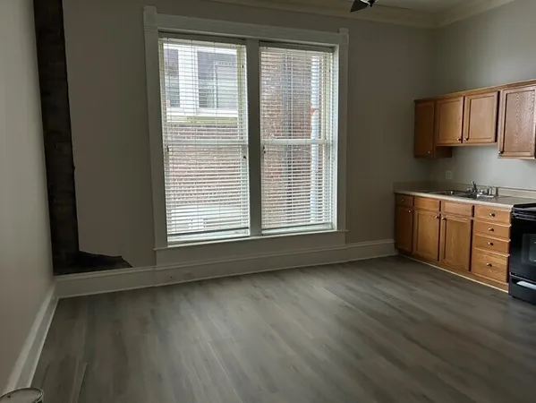 a view of a kitchen with wooden floor and electronic appliances