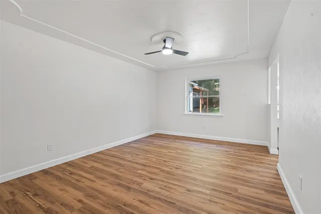 wooden floor in an empty room with a window