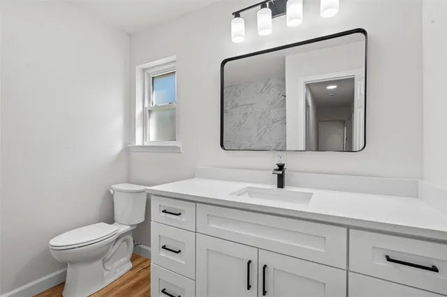 a bathroom with a toilet sink and mirror