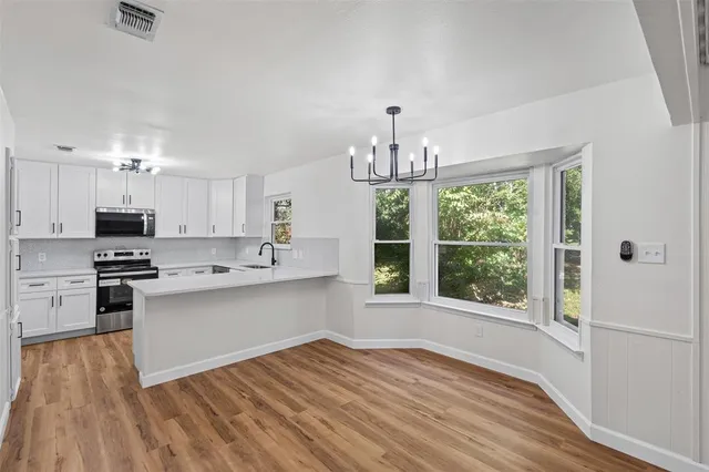 a kitchen with stainless steel appliances a lot of counter space and wooden floors
