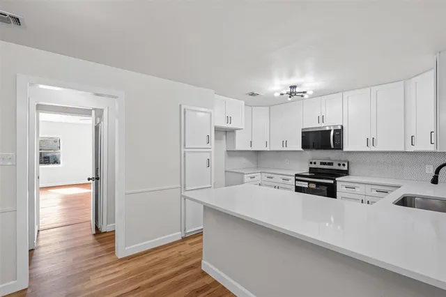 a kitchen with stainless steel appliances a refrigerator sink and microwave