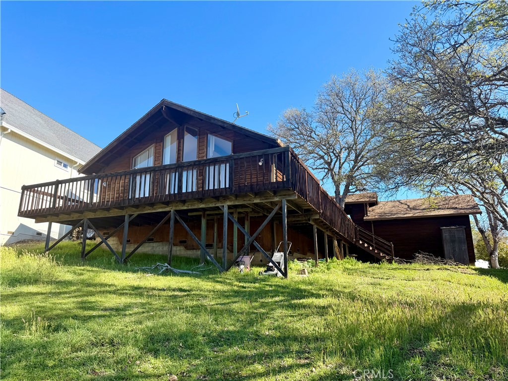 a view of a house with a yard and a large tree