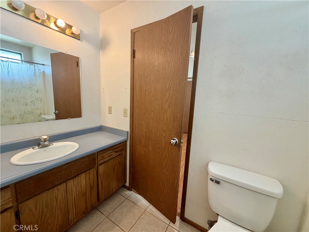 20764 Powder Horn Road Hidden Valley Lake, CA 95467 - Photo 15 of 27 a bathroom with a granite countertop sink a toilet and a mirror