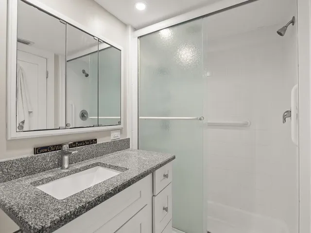 a bathroom with a granite countertop sink and a mirror
