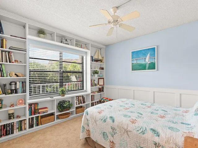 a bedroom with a large bed cabinets and a window