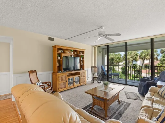 a living room with furniture a flat screen tv and a large window