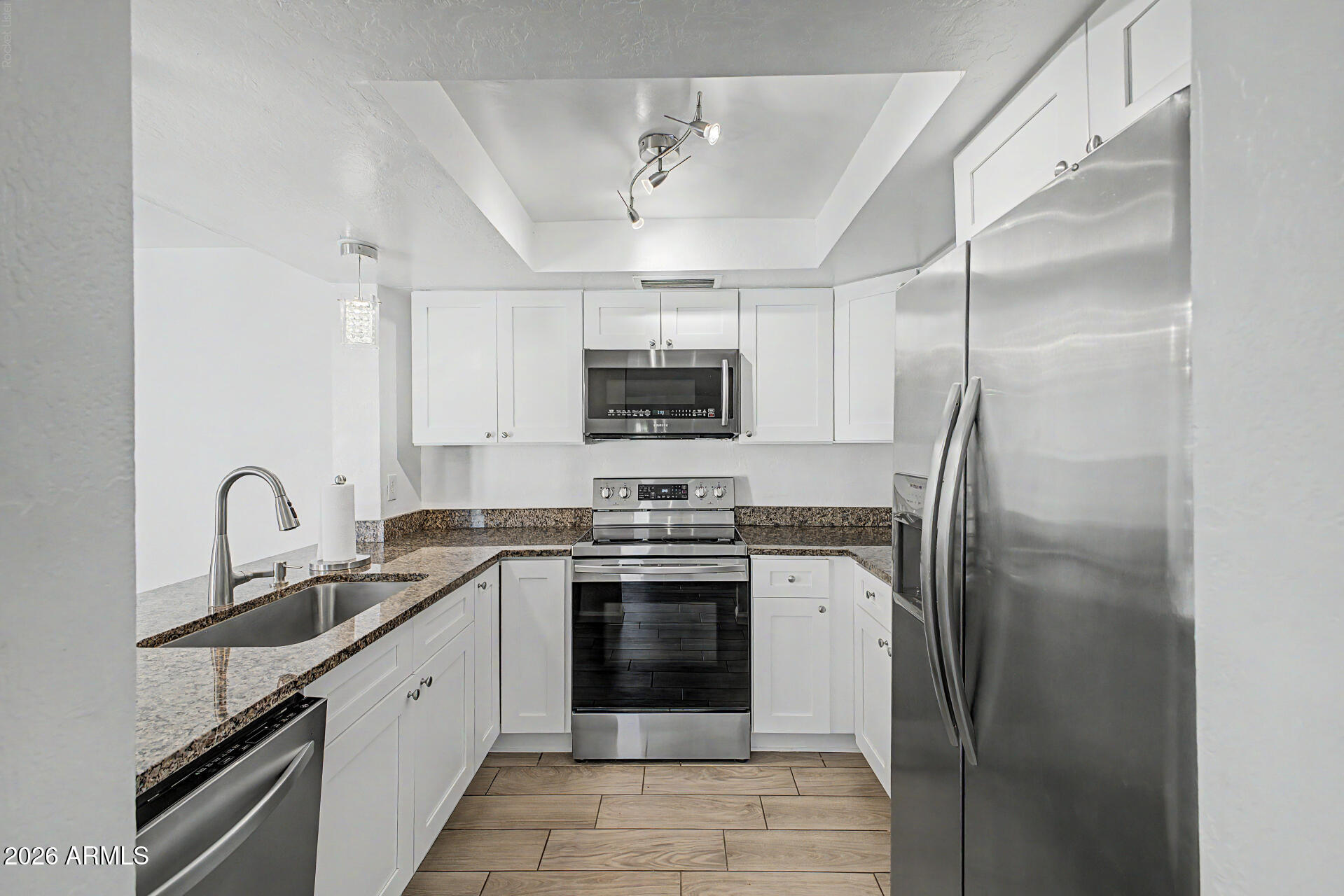 2455 East Broadway Road, Unit 103 Mesa, AZ 85204 - Photo 8 of 22 a kitchen with stainless steel appliances granite countertop a sink stove and refrigerator