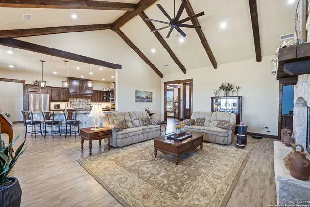 a kitchen with stainless steel appliances kitchen island granite countertop a table chairs in it and wooden floor