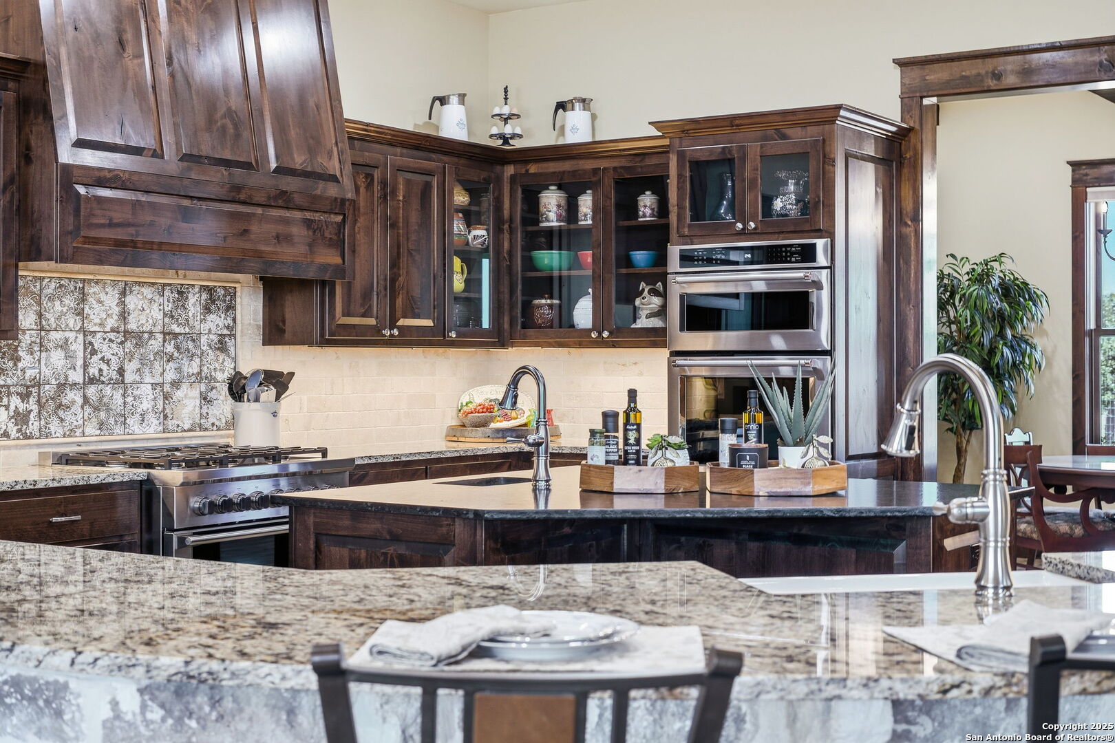 601 Garrison Road Fredericksburg, TX 78624 - Photo 13 of 77 a kitchen with stainless steel appliances kitchen island granite countertop a table chairs in it and wooden floor