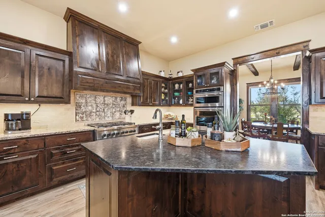 a kitchen with kitchen island granite countertop a sink stove and refrigerator