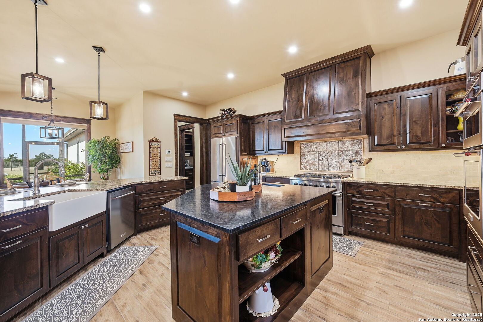 601 Garrison Road Fredericksburg, TX 78624 - Photo 17 of 77 a kitchen with kitchen island granite countertop a sink stove and refrigerator