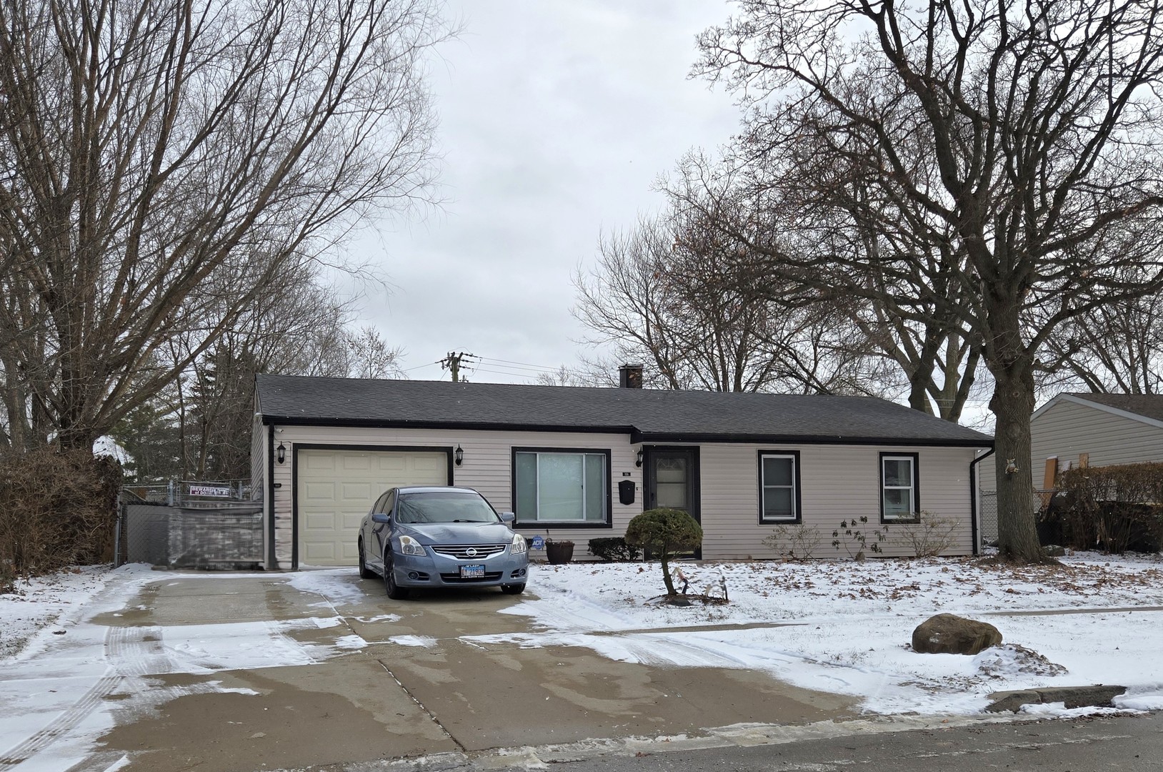 a front view of a house with cars parked