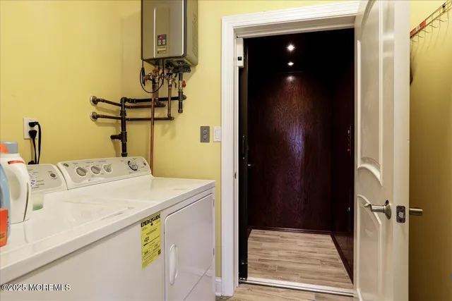 a view of a hallway with entryway and wooden floor