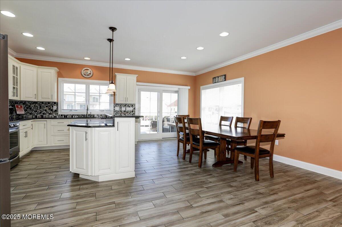 1874 Compass Court Toms River, NJ 08753 - Photo 7 of 12 a kitchen with stainless steel appliances granite countertop wooden floor a dining table and chairs
