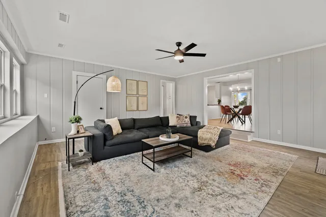 a living room with furniture and a wooden floor